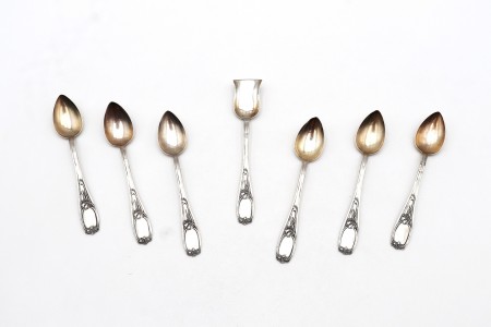 Conjunto de seis colheres de chá e pá de açúcar em prata com os cabos relevados.